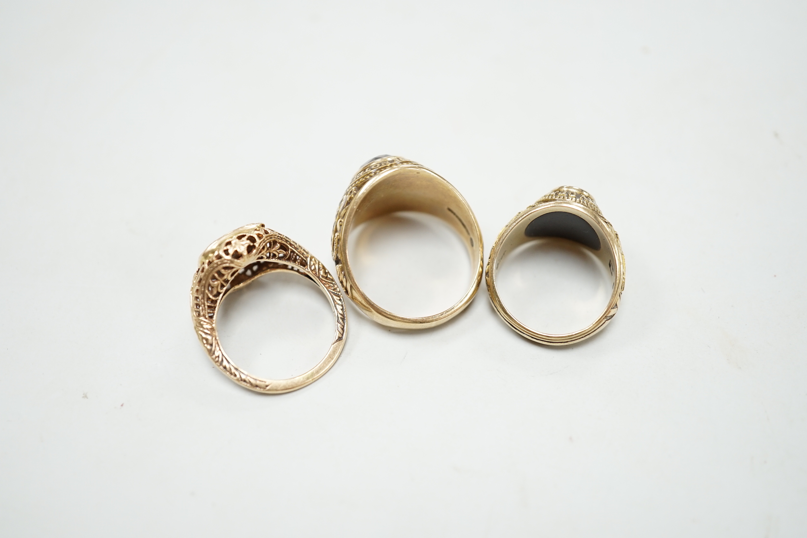 Three assorted American 10k dress rings, two set with gems, one signed John Roberts, gross weight 18.9 grams.